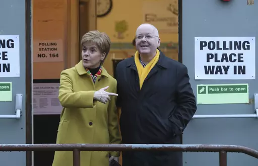 Scottish First Minister Nicola Sturgeon poses for the media with husband Peter Murrell, outside polling station in Glasgow, Scotland, on Dec. 12, 2019. British media are reporting that the husband of former Scottish National Party leader Nicola Sturgeon has been arrested in a party finance probe on Wednesday, April 5, 2023. (AP Photo/Scott Heppell, File)