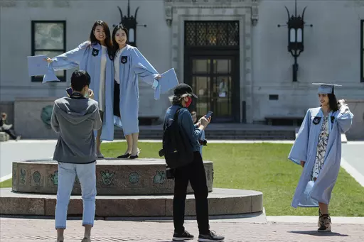 Columbia University class of 2020 graduates pose for photographs on Commencement Day on Wednesday, May 20, 2020, in New York. After three years, the pandemic-era freeze on student loan payments will end in late August. It might seem tempting to just keep not making payments, but the consequences can be severe, including a hit to your credit score and exclusion from future aid and benefits. (AP Photo/Frank Franklin II, File)