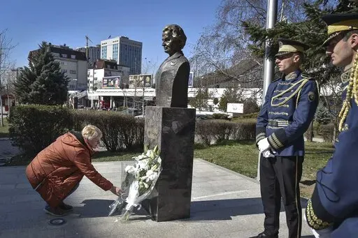 A woman lays a bouquet of flowers at the foot of a statue of former U.S. Secretary of State Madeleine Albright, in Pristina, Kosovo, Thursday, March 24, 2022. A monument in Kosovo, a snake named after her in Serbia. Madeleine Albright was either loved or hated in the Balkans for her pivotal role during the southern European region's wars of the 1990s. Following the former U.S. secretary of state's death on Wednesday at age 84, how her legacy is viewed from the Balkans mostly depends on whether o
