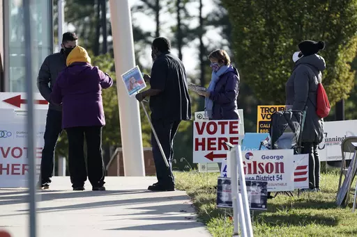 Voters are assisted at a polling location at the South Regional Library in Durham, N.C., Nov. 3, 2020. In North Carolina and Wisconsin, Republicans are trying to seize power over elections and redistricting. Both states are evenly divided political battlegrounds where the GOP controls an outsized number of seats in the state legislature. In Wisconsin, that's largely due to a gerrymander that locks in a GOP majority. (AP Photo/Gerry Broome, File)