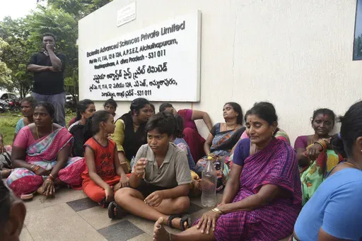 Relatives of the victims killed in a fire triggered by an explosion at the Escientia Advanced Sciences Private Ltd., a pharmaceutical company, sit outside the factory, in Atchutapuram, Andhra Pradesh state, India, Thursday, Aug. 22, 2024. (AP Photo)