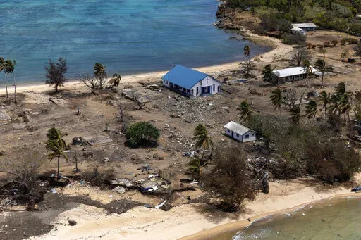 In this photo provided by the Australian Defence Force, debris from damaged building and trees are strewn around on Atata Island in Tonga, on Jan. 28, 2022, following the eruption of an underwater volcano and subsequent tsunami. Tonga's main internet connection to the rest of the world has finally been restored more than five weeks after the huge volcanic eruption and tsunami severed a crucial undersea cable. The fiber-optic cable is now fully operational again after being reconnected Tuesday, F