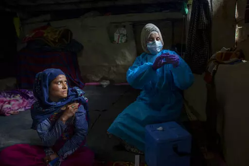 Masrat Farid, a healthcare worker, prepares to administer a dose of Covishield vaccine to Rubia Begum inside a hut during a COVID-19 vaccination drive in Gagangeer, northeast of Srinagar, Indian controlled Kashmir on June 22, 2021. Farid has traveled long distances to vaccinate mostly shepherds and nomadic herders in the remote meadows of the Himalayan region of Indian-controlled Kashmir. (AP Photo/Dar Yasin)