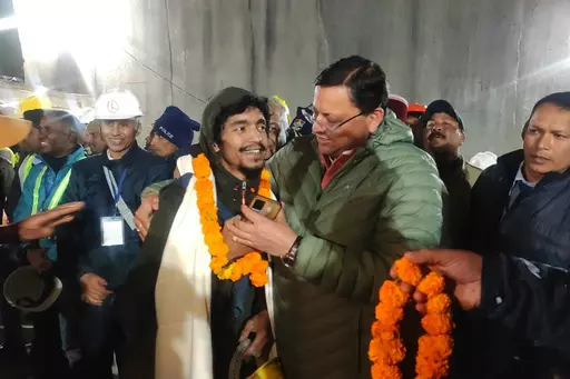 This handout photo provided by the Uttarakhand State Department of Information and Public Relations shows Pushkar Singh Dhami, right, Chief Minister of the state of Uttarakhand, greeting a worker rescued from the site of an under-construction road tunnel that collapsed in Silkyara in the northern Indian state of Uttarakhand, India, Tuesday, Nov. 28, 2023. Dhami said eight workers were rescued so far on Tuesday. The laborers are being pulled out through a passageway made of welded pipes which res