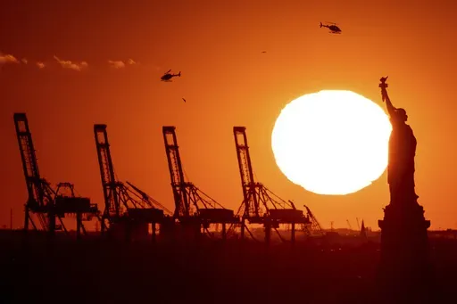 Cranes at the Port of New York and New Jersey appear behind the Statue of Liberty, Nov. 20, 2022, in a photo taken from New York. (AP Photo/Julia Nikhinson, File)