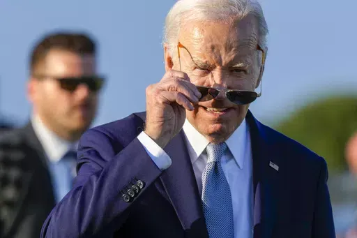U.S. President Joe Biden puts on his sun glasses after watching a skydiving demo during the G7 world leaders summit at Borgo Egnazia, Italy, Thursday, June 13, 2024. (AP Photo/Luca Bruno)