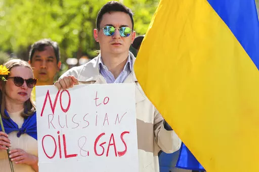 Ukrainian demonstrators demand an embargo on Russian oil during a protest in front of EU institutions prior to an extraordinary meeting of EU leaders to discuss Ukraine, energy and food security at the Europa building in Brussels, Monday, May 30, 2022. (AP Photo/Olivier Matthys)
