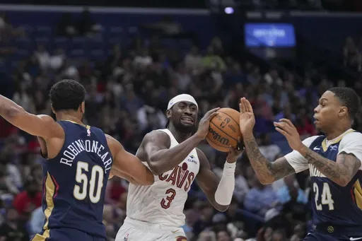 Cleveland Cavaliers guard Caris LeVert (3) battles between New Orleans Pelicans forward Jeremiah Robinson-Earl (50) and guard Jordan Hawkins (24) in the first half of an NBA basketball game in New Orleans, Wednesday, Nov. 6, 2024. (AP Photo/Gerald Herbert)
