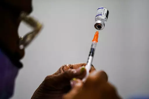 A syringe is prepared with the Pfizer COVID-19 vaccine at a vaccination clinic at the Keystone First Wellness Center in Chester, Pa., Dec. 15, 2021.  Pfizer says tweaking its COVID-19 vaccine to better target the omicron variant is safe and boosts protection. Saturday, June 25, 2022 announcement comes just days before regulators debate whether to offer Americans updated booster shots this fall. (AP Photo/Matt Rourke, File)