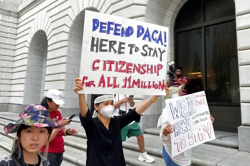 Demonstrators hold up signs outside the 5th U.S. Circuit Court of Appeals building in New Orleans on Wednesday, July 6, 2022. A panel of 5th Circuit judges heard arguments on an Obama-era program that prevents the deportation of thousands of immigrants brought into the United States as children. A federal judge in Texas last year declared the Deferred Action for Childhood Arrivals program illegal — although he agreed to leave the program intact for those already benefiting from it while his or