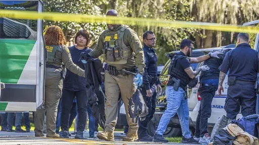 Law enforcement officers detain migrants in the area in Coral Gables, Fla., Jan. 28, 2025. (Pedro Portal/Miami Herald via AP File)