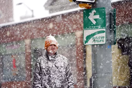 A man is covered in snow on Fenn Street in Pittsfield, Mass, Friday, Dec. 16, 2022. (Ben Garver/The Berkshire Eagle via AP)