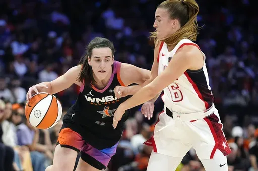 Caitlin Clark, left, of Team WNBA, dribbles against Sabrina Ionescu (6), of Team USA, during the second half of a WNBA All-Star basketball game Saturday, July 20, 2024, in Phoenix. (AP Photo/Ross D. Franklin)