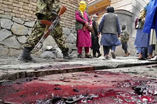 Taliban fighters stand guard at the site of an explosion in front of a school, in Kabul, Afghanistan, Tuesday, April 19, 2022. An Afghan police spokesman says explosions targeting educational institutions in Kabul have killed at least six civilians and injured over 10 others. Khalid Zadran said Tuesday the blasts occurred in the mostly-Shiite Muslim area in the west of Afghanistan's capital. (AP Photo/Ebrahim Noroozi)