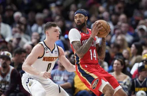 New Orleans Pelicans forward Brandon Ingram, right, looks to pass the ball as Denver Nuggets guard Christian Braun defends during the first half of an NBA basketball game Thursday, March 30, 2023, in Denver. (AP Photo/David Zalubowski)
