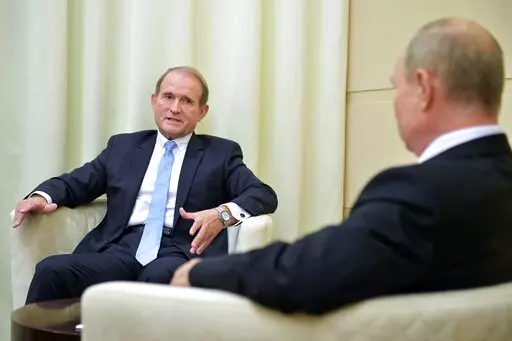 Ukrainian tycoon Viktor Medvedchuk, left, speaks to Russian President Vladimir Putin during a meeting at the Novo-Ogaryovo residence outside Moscow, Russia, Oct. 6, 2020. The detention on Tuesday, April 12, 2022 of fugitive Ukrainian oligarch Viktor Medvedchuk, who is both the former leader of a pro-Russian opposition party and a close associate of Russian leader Vladimir Putin, was met with enthusiasm in Kyiv — and irritation in Moscow.  (Sputnik, Kremlin Pool Photo via AP, file)