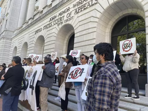 Demonstrators gather outside federal court buildings in New Orleans on Wednesday, April 3, 2024, to protest a Texas law known as SB4. Texas officials appeared before a three-judge federal appeals panel to defend a state law that would allow police to arrest migrants for illegally entering the United States, a week after the same three judges put the law on hold. (AP Photo by Kevin McGill)