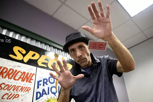 Paul Carpenter, a New Orleans magician, performs card tricks during an interview in New Orleans, Friday, Feb. 23, 2024. Carpenter says he was hired in January by Steve Kramer, who has worked on ballot access for Democratic presidential candidate Dean Phillips, to use AI software to imitate President Joe Biden's voice to convince New Hampshire Democrat voters not to vote in the state's presidential primary. (AP Photo/Matthew Hinton)