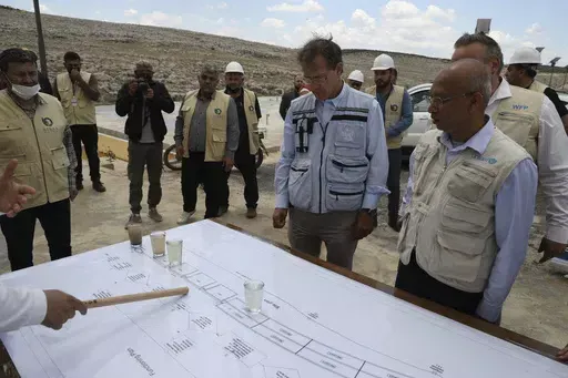U.N. Deputy Regional Humanitarian Coordinator for the Syria Crisis David Carden, center, inspects a wastewater treatment project in the village of Bhora, in Idlib province, Syria, Tuesday, May 14, 2024. Syria's devastating civil war, now in its 14th year, remains largely frozen and so are efforts to find a viable political solution to end it, while millions of Syrians have been pulled into poverty, and struggle with accessing food and health care as the economy deteriorates across the country's 