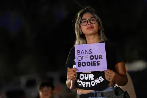 Celina Washburn protests outside the Arizona Capitol to voice her dissent with an abortion ruling, Friday, Sept. 23, 2022, in Phoenix. An Arizona judge ruled the state can enforce a near-total ban on abortions that has been blocked for nearly 50 years. The law was first enacted decades before Arizona became a state in 1912. (AP Photo/Matt York, File)
