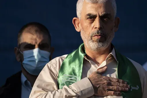 Yahya Sinwar, Palestinian leader of Hamas in the Gaza Strip, places his hand over his heart on stage after greeting supporters at a rally on May 24, 2021, in Gaza City, the Gaza Strip. (AP Photo/John Minchillo, File)