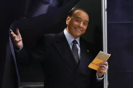 Silvio Berlusconi comes out of a voting booth before casting his ballot at a polling station in Milan, Italy, Sept. 25, 2022. Berlusconi, the boastful billionaire media mogul who was Italy's longest-serving premier despite scandals over his sex-fueled parties and allegations of corruption, died, according to Italian media. He was 86. (AP Photo/Antonio Calanni, File )