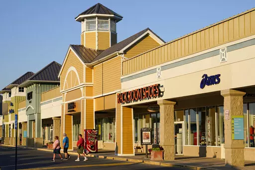 Shoppers walk outside an outlet mall in Rehoboth Beach, Del., Saturday, June 4, 2022. President Joe Biden faces a delicate trade-off as he tries to help his fellow Democrats in the upcoming midterm elections. He needs U.S. consumers to pull back just enough so that inflation eases, but not so much that the economy risks plunging into a recession. (AP Photo/Patrick Semansky)