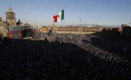People gather in the Zocalo to celebrate Mexico's newly sworn-in president, Andres Manuel Lopez Obrador, in Mexico City, Dec. 1, 2018. Lopez Obrador swept into office with the motto laying out his administration’s priorities: “For the good of all, first the poor.” (AP Photo/Marco Ugarte, File)