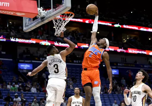 Oklahoma City Thunder guard Shai Gilgeous-Alexander (2) dunks over New Orleans Pelicans guard CJ McCollum (3) during the fourth quarter of an NBA basketball game in New Orleans, Saturday, March 11, 2023. (AP Photo/Derick Hingle)