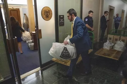 Aides bring in food for a House Republican closed-door caucus to decide who to nominate for speaker of the House, on Capitol Hill, Wednesday, Oct. 11, 2023, in Washington. (AP Photo/Alex Brandon)