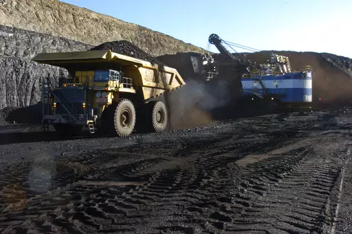 In this Nov. 15, 2016 photo, a haul truck with a 250-ton capacity carries coal after being loaded from a nearby mechanized shovel at the Spring Creek strip mine near Decker, Mont. The mine is in the Powder River Basin of Montana and Wyoming, the largest source of coal in the U.S. Environmentalists are pushing to end mining because emissions from burning coal help drive climate change. (AP Photo/Matthew Brown)