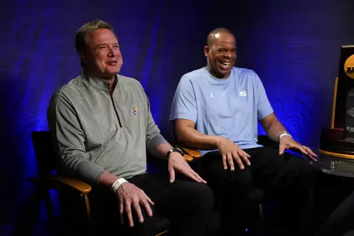 Kansas head coach Bill Self, left, and North Carolina head coach Hubert Davis talk during a CBS Sports interview ahead of the Men's Final Four NCAA basketball tournament, Sunday, April 3, 2022, in New Orleans. North Carolina will face Kansas in the final game on Monday. (AP Photo/David J. Phillip)