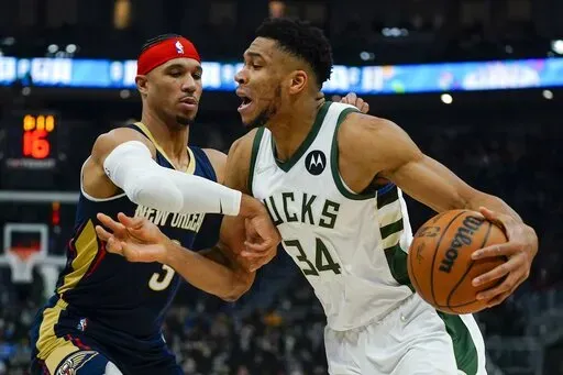 Milwaukee Bucks' Giannis Antetokounmpo tries to drive past New Orleans Pelicans' Willy Hernangomez during the first half of an NBA basketball game Saturday, Jan. 1, 2022, in Milwaukee. (AP Photo/Morry Gash)