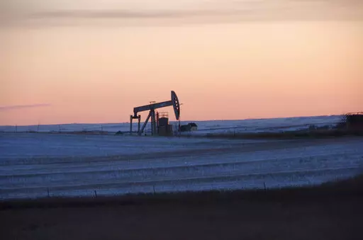 FILE -In this Feb. 25, 2015 photo, a pump jack for pulling oil from the ground is seen near New Town, N.D. The Biden administration has reached a legal settlement requiring officials to re-examine potential climate damages from oil and gas leases in Montana and North Dakota that were put up for sale under the Trump administration. The settlement involves public lands totaling 91 square miles. It was detailed in documents filed Tuesday, Sept. 6, 2022 in U.S. District Court in Montana. (AP Photo/M