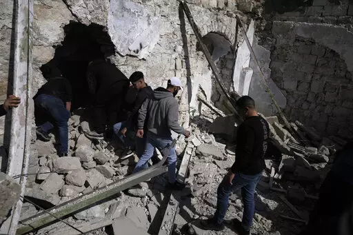Palestinians inspect the ruins of a militant hideout destroyed during a raid by Israeli forces in the Old City of Nablus in the West Bank, Wednesday, Feb. 22, 2023. Israeli troops moved into the city, setting off fighting that killed several Palestinians, including a 72-year-old man, Palestinian health officials said. The Israeli military gave few details about its operation in the northern city, which is known as a militant stronghold, and the army frequently operates there. (AP Photo/Majdi Moh
