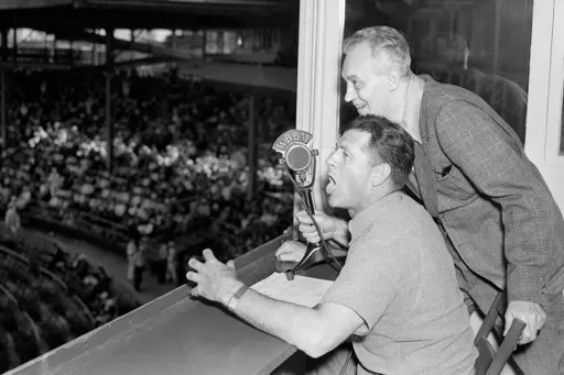 Baseballer Charlie Grimm,left, deposed by the Chicago Cubs in favor of Gabby Hartnett as manager, takes up new duties as a radio broadcaster at the ball games at Wrigley Field in Chicago, July 25, 1938. He's assisted by Pat Flanagan, a broadcasting colleague. Many baseball fans, especially older ones, originally fell in love with America’s pastime by listening to ballgames on AM radio. But several major automakers are eliminating broadcast AM radio from newer models, prompting lawmakers on Cap