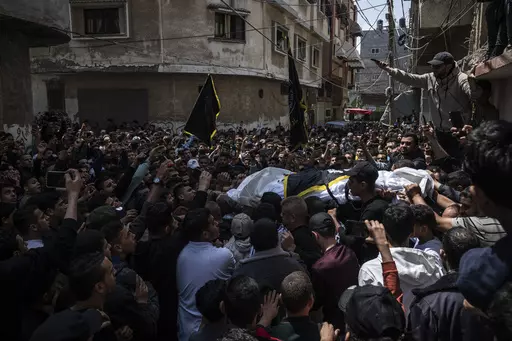 Mourners carry the bodies of Khalil Bahtini, the Islamic Jihad militant group's commander for the northern Gaza Strip, his wife and son, who were killed in an Israeli airstrike at their family home, during their funeral, in Gaza City, Tuesday, May 9, 2023. Bahtini was among three senior Islamic Jihad commanders killed in targeted airstrikes early Tuesday. Palestinian health officials said at least 10 others were killed, including wives of two of the militants, several of their children and other