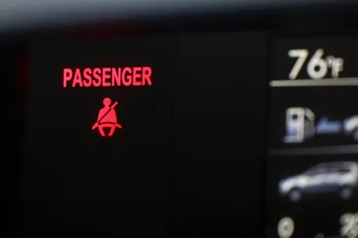 A seat belt warning sign for the right front passenger seat is displayed in a vehicle on Monday, Aug. 21, 2023. (AP Photo/Jenny Kane, file)