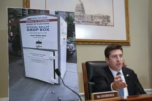 Bryan Steil, R-Wis., chairman of the Committee on House Administration, displays a large photo of an unlocked election ballot drop box in Washington, during a hearing about noncitizen voting in U.S. elections. on Capitol Hill, Thursday, May 16, 2024 in Washington. In recent months, the specter of noncitizens voting in the U.S. has erupted into a leading rallying cry for Republicans. (AP Photo/John McDonnell)