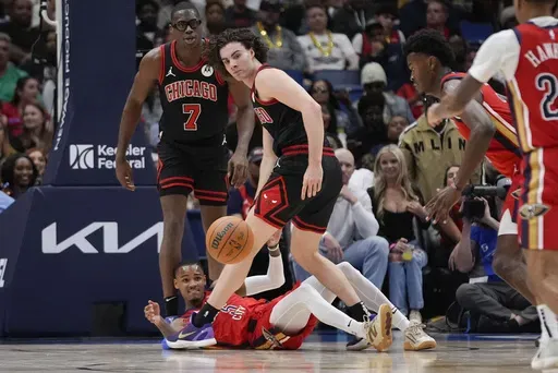 New Orleans Pelicans guard Dejounte Murray (5) passes a loose ball away from Chicago Bulls forward Jalen Smith (7) and guard Josh Giddey in the second half of an NBA basketball game in New Orleans, Wednesday, Oct. 23, 2024. The Pelicans won 123-111. (AP Photo/Gerald Herbert)