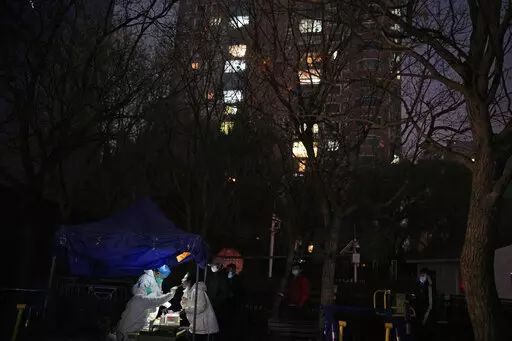 A resident gets swabbed for the COVID test outside a neighborhood in Beijing, Saturday, Nov. 19, 2022. (AP Photo/Ng Han Guan)