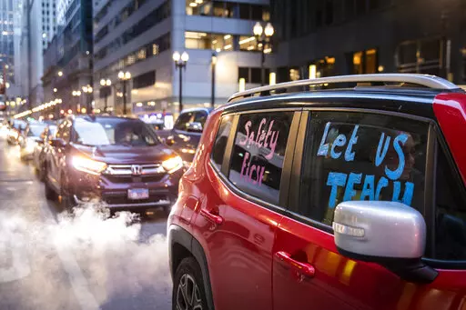 Members of the Chicago Teachers Union and supporters stage a car caravan protest outside City Hall in the Loop, Wednesday evening, Jan. 5, 2022. Chicago school leaders canceled classes in the nation’s third-largest school district for the second straight day after failing to reach an agreement with the teachers union over remote learning and other COVID-19 safety protocols. (Ashlee Rezin /Chicago Sun-Times via AP)