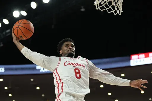 Houston guard Mylik Wilson (8) dunks the ball during the second half of an NCAA college basketball game against Louisiana Lafayette, Wednesday, Nov. 13, 2024, in Houston. (AP Photo/Kevin M. Cox)
