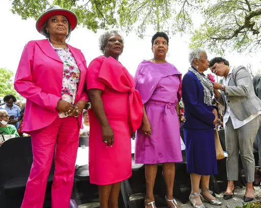 From left, Gail Etienne, Leona Tate and Tessie Prevost, known as the McDonogh Three, stand in front of the former McDonogh NO. 19 Elementary School that they helped desegregate as children, as Mayor LaToya Cantrell helps pin a flower on the dress of Dorothy Prevost, right, during a ceremony renaming the building the Tate Etienne & Prevost Center which will serve as a community center in New Orleans, La. Wednesday, May 4, 2022. (Max Becherer/The Times-Picayune/The New Orleans Advocate via AP)