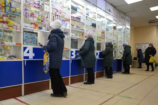 Customers stand at the windows buying medicines in a pharmacy in St. Petersburg, Russia, Friday, April 1, 2022. (AP Photo)