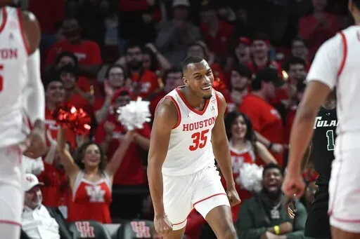 Houston forward Fabian White Jr. (35) smiles after dunking the ball against Tulane during the first half of an NCAA college basketball game Wednesday, Feb. 2, 2022, in Houston. (AP Photo/Justin Rex)