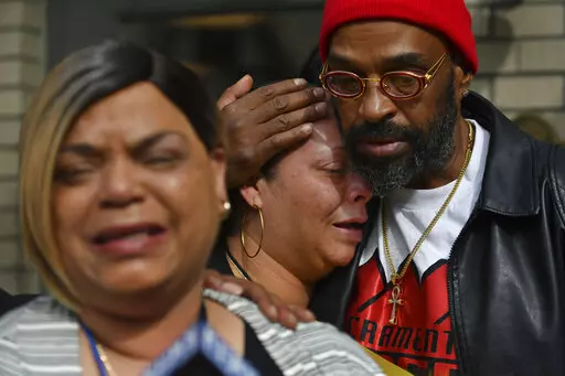 Antoinette Walker cries on the shoulder of Frank Turner as Penelope Scott speaks to the media during an interview at the corner of 10th and K street in Sacramento, Calif., on Monday, April 4, 2022. Walker is the older sister of De'vazia Turner, who was shot and killed during a mass shooting a day earlier. Frank Turner and Penelope Scott are the mother and father of De'vazia Turner. Multiple people were killed and injured in the shooting  (Jose Carlos Fajardo/Bay Area News Group via AP)