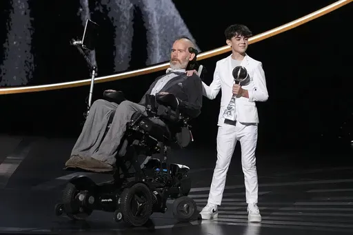 Steve Gleason, left, recieves the Arthur Ashe Award for Courage, held by his son Rivers, right, at the ESPY awards on Thursday, July 11, 2024, at the Dolby Theatre in Los Angeles. (AP Photo/Mark J. Terrill)
