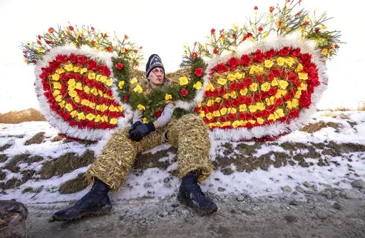 A villager, dressed in a traditional bear costume, celebrates the Malanka festival in the village of Krasnoilsk, Ukraine, Friday, Jan. 14, 2022. Dressed as goats, bears, oxen and cranes, many Ukrainians rang in the new year last week in the colorful rituals of the Malanka holiday. Malanka, which draws on pagan folk tales, marks the new year according to the Julian calendar, meaning it falls on Jan. 13-14. In the festivities, celebrants go from house to house, where the dwellers offer them food. 