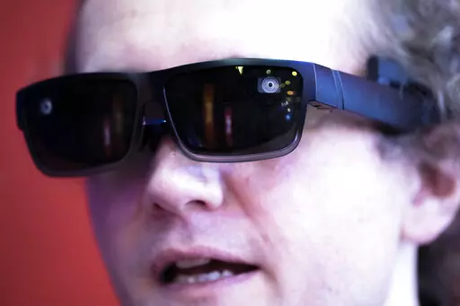 A worker displays XRAI glasses during the Mobile World Congress 2023 in Barcelona, Spain, on Wednesday, March 1, 2023. After three years of pandemic disruption, MWC, also known as Mobile World Congress, kicked off Monday in Barcelona, Spain, with mobile phone makers showing off new devices and telecom industry executives perusing the latest networking gear and software. (AP Photo/Joan Mateu Parra)
